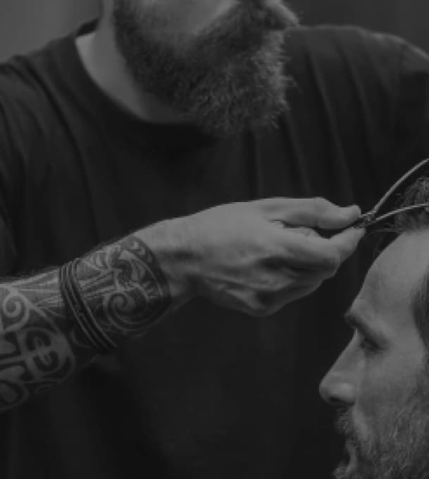 Фото мастера, который стрижет клиента в BarberShop